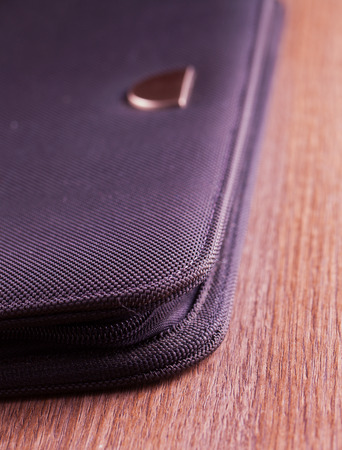 Elegant black folder over a wooden backgroundの写真素材