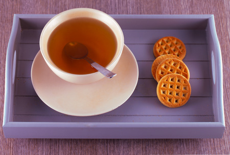 Tea and biscuits over a wooden trayの写真素材