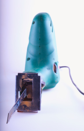 Green chainsaw over gray background, focus on the first part of the sawの写真素材