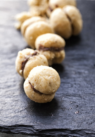 Biscuits "Baci di dama" in a row over black stoneの写真素材