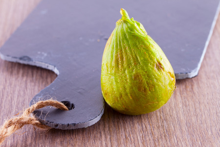 Green fig standing near a black chopping board
の写真素材