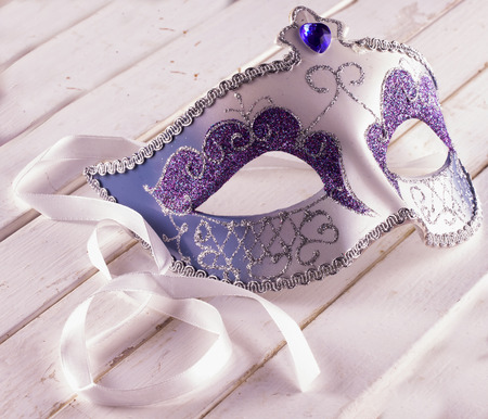Venetian artisanal mask for Carnival over white wooden tableの写真素材