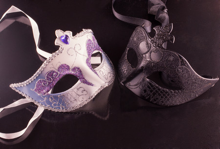 Venetian masks over a black reflecting backgroundの写真素材