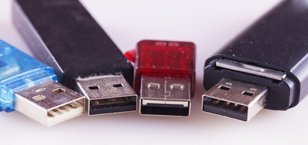 Four usb pen drives over white background