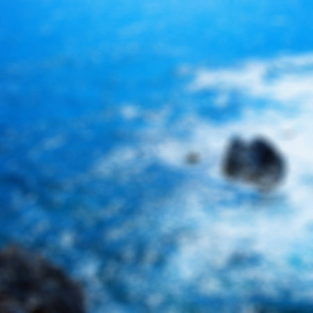 Blurred background of rocks in the sea with foam, square imageの写真素材