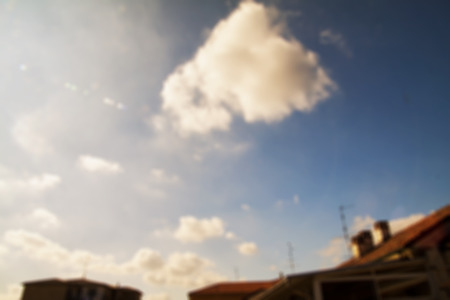 Cloudy sky over houses, blurred background, horizontal imageの写真素材