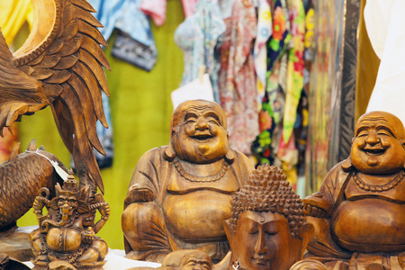 Smiling wooden buddah statue between other wooden statues horizontal imageの写真素材