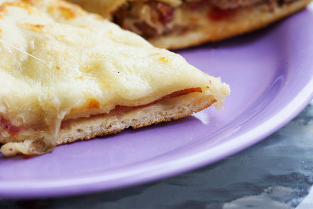 Focaccia with ham and cheese over purple plate, horizontal imageの写真素材