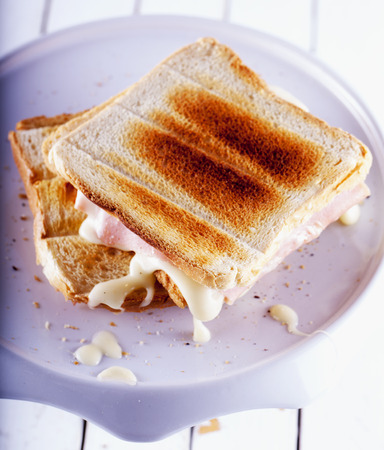 Toast with cheese and ham over white stand, vertical imageの写真素材