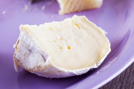 Brie cheese over purple plate. horizontal imageの写真素材