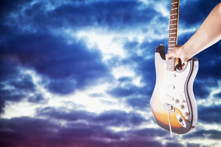 Guitar with cloudy sky on the back, horizontal imageの写真素材