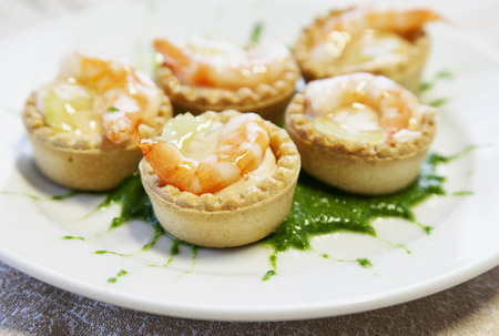 Pastries with shrimp over green sauce, over white plate, horizontal imageの写真素材