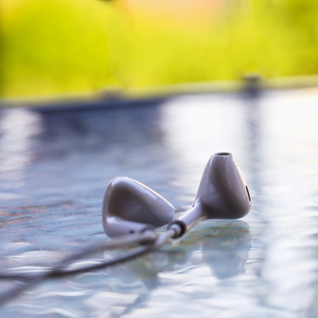 White headset over glass table, green background, square imageの写真素材