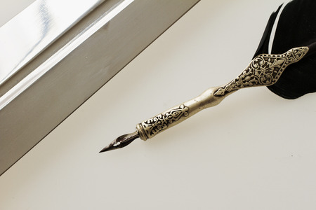 Old pen and sword over gray background, horizontal imageの写真素材