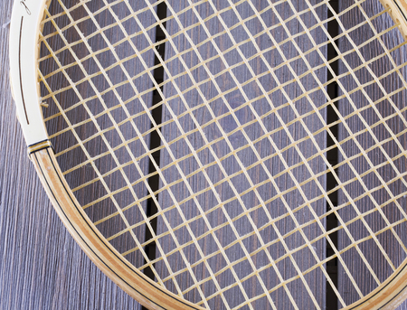 Wooden old tennis racket over wooden background, horizontal image