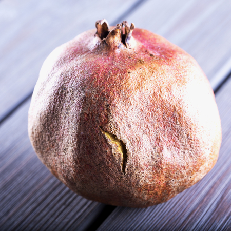 Pomegranate over wooden table, close up, square imageの写真素材