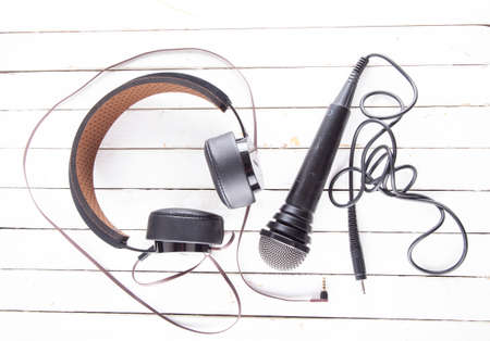 Headphones and microphone over white wood, horizontal imageの写真素材