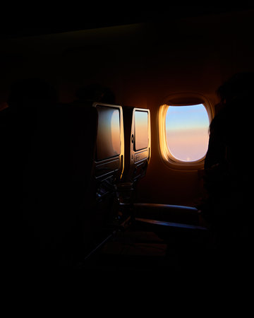 Airplane window view at sunset in the cabin. Travel concept.の写真素材