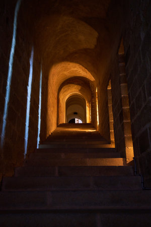 Staircase in the old church at night with light in the endの写真素材