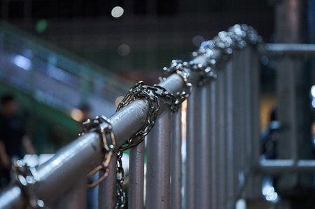 chain on the fence in the city at night, closeup of photo