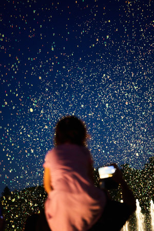 Fountain in the city at night. Blurred silhouette of a girl.の写真素材
