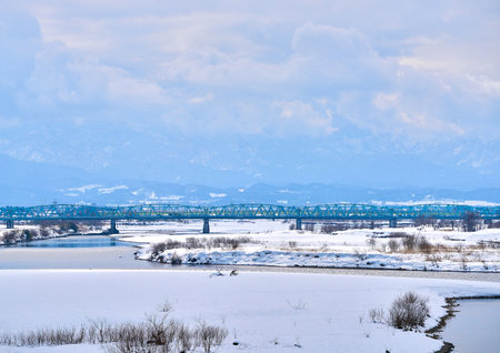 Landscape view of the frozen river and the bridge in winter.の写真素材