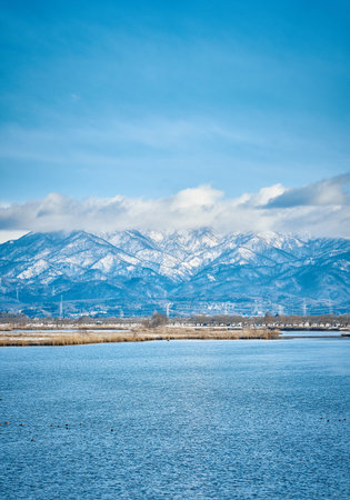 Lake Kawaguchiko with snow covered mountains in the background.の写真素材