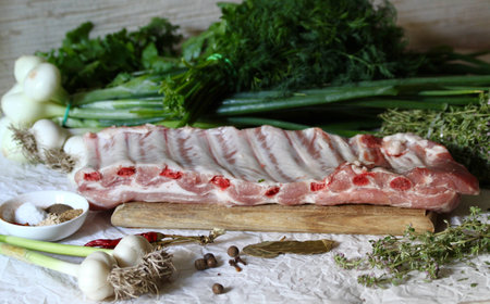 Raw pork ribs on a wooden cutting board for dinnerの素材