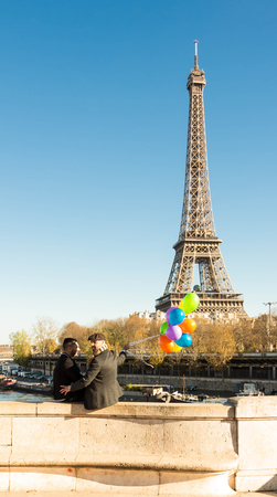 Paris; France-Novembre 22, 2015 : The couple of men with balloons and Eiffel tower in the background, Paris, France.のeditorial素材