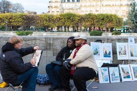 Paris, France- November 22, 2015 :The couple of tourists posing for street painter near Notre Dame cathedral  in Paris, France.のeditorial素材