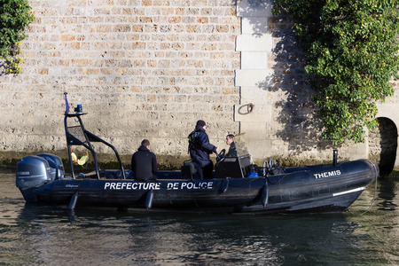 Paris; France-November 28, 2015 : The Police boat is patrolling on the Seine river near Notre Dame cathedral in Paris, France.のeditorial素材