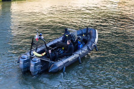 Paris; France-November 28, 2015 : The Police boat is patrolling on the Seine river near Notre Dame cathedral in Paris, France.のeditorial素材