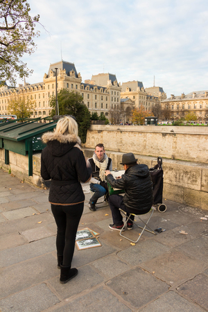 Paris; France-November 22; 2015: The unidentified tourist posing for painter near Notre Dame cathedral in Paris, France.のeditorial素材