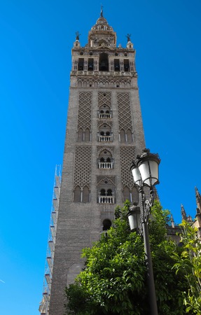 Famous tower of Giralda, Islamic architecture built by the Almohads and crowned by a Renaissance bell tower with the statue of Giraldillo at its highest point, Seville Cathedral.の写真素材