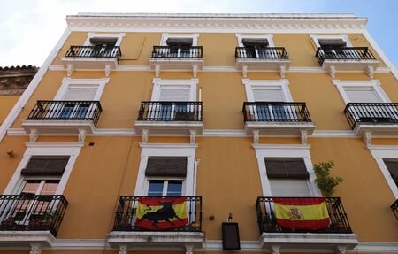 Traditional colorful building facade decorated with national flags in Seville old town, Spain.の写真素材