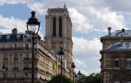 View of the bell towers of Notre-Dame de Paris cathedral and traditional street lamps in the foreground.の写真素材