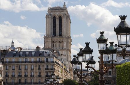 View of the bell towers of Notre-Dame de Paris cathedral and traditional street lamps in the foreground.の写真素材