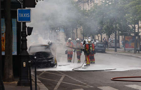 PARIS, FRANCE - MAY 23, 2020 : Accident in the streets of Paris . Some Firemen extinguishing the fire the car near Triumphal Arch in Paris.のeditorial素材