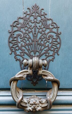 Royal style doorknocker on turquoise door. Paris.の写真素材