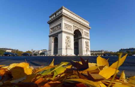 The famous Triumphal Arch and autumnal leaves in the foreground at sunny day , Paris, France.の写真素材