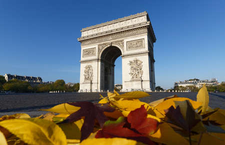 The famous Triumphal Arch and autumnal leaves in the foreground at sunny day , Paris, France.の写真素材