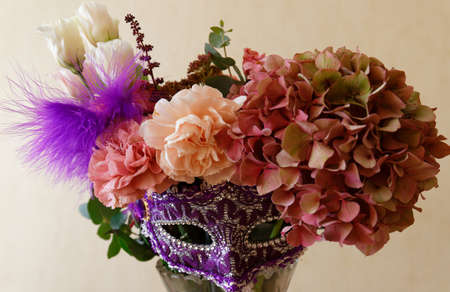 The beautiful flower bunch with fixed carnival mask on plain background.の写真素材