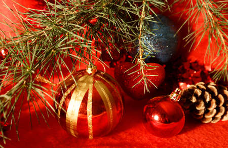 Christmas decoration: baubles with cones and fir tree branches isolated on red backgroundの写真素材