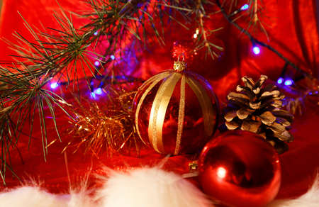 Christmas decoration: baubles with cones and fir tree branches isolated on red backgroundの写真素材