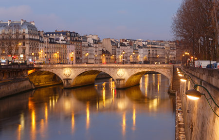 Stone bridge Pont au Change in Paris at the dusk. On the left are towers of Conciergerie, on right northern bank of river Seine. Paris.の写真素材