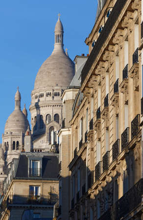 The facade of Parisian building and Sacre Coeur basilica in the background , France.の写真素材