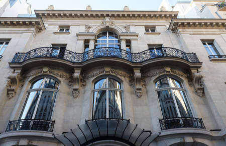 The facade of traditional French house with typical balconies and windows. Paris.の写真素材