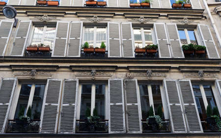 The facade of traditional French house with typical balconies and windows. Paris.の写真素材