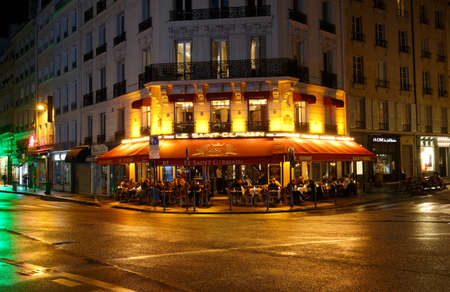 The traditional French cafe restaurant Le Saint Germain at rainy night . It located on Saint-Germain boulevard in Paris, France.のeditorial素材