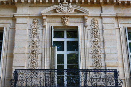 Architectural fragments of the facade of ancient house in Paris- window decorated with floral bas relief ornament.の写真素材